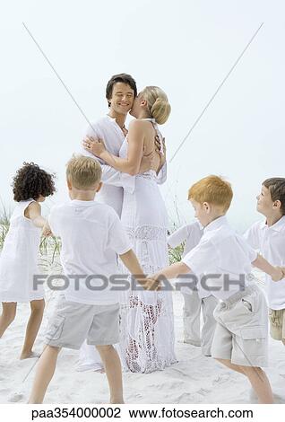 Children forming circle around couple on beach View Large Photo Image Stock Image - Children forming circle around couple on beach. Fotosearch