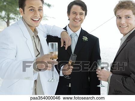 Stock Photograph - Groom standing with two male friends. Fotosearch
