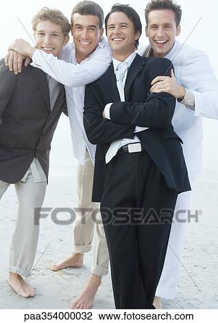 Stock Image - Groom with friends on beach. Fotosearch