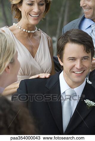 Outdoor wedding party, young groom with mother-in-law in background View Large Photo Image Stock Image - Outdoor wedding party, young groom with mother-in-law in background. Fotosearch