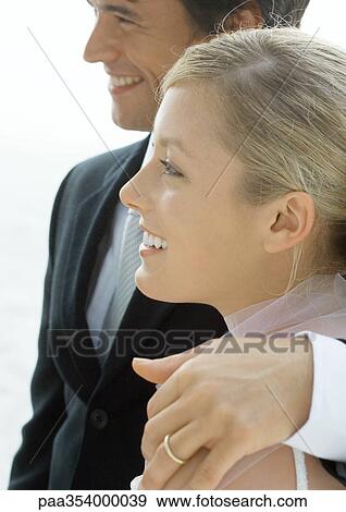 Young married couple, man with arm around woman's shoulder View Large Photo Image Stock Photo - Young married couple, man with arm around woman's shoulder. Fotosearch