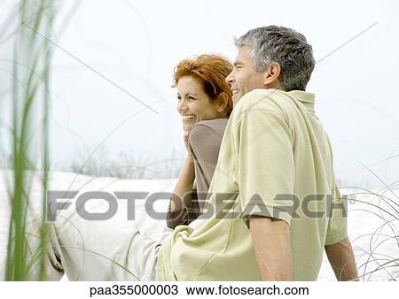 Mature couple sitting on beach together View Large Photo Image Stock Image - Mature couple sitting on beach together. Fotosearch