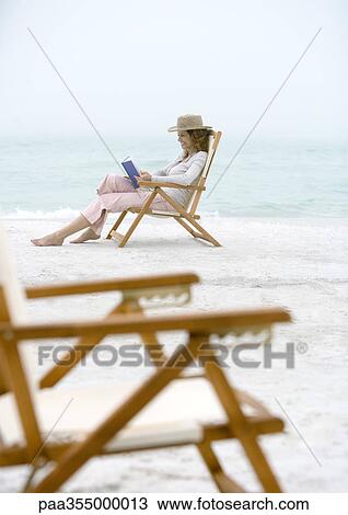 Woman on beach sitting in beach chair View Large Photo Image Stock Image - Woman on beach sitting in beach chair . Fotosearch