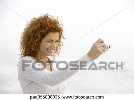 Stock Photography - Woman using digital camera. Fotosearch