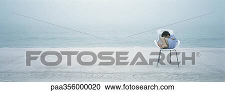 Boy curled up in chair on beach View Large Photo Image Stock Image - Boy curled up in chair on beach. Fotosearch