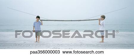 Boys speaking through stick on beach View Large Photo Image Stock Image - Boys speaking through stick on beach. Fotosearch