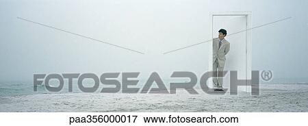 Man peeking through doorframe on beach View Large Photo Image Stock Photo - Man peeking through doorframe on beach. Fotosearch