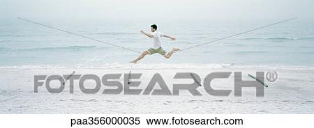 Man running and jumping over logs on beach View Large Photo Image Stock Photography - Man running and jumping over logs on beach. Fotosearch