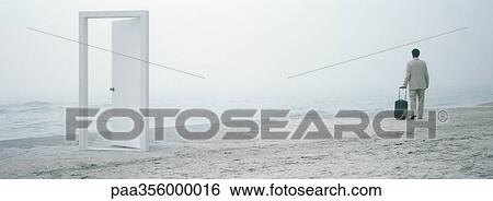 Man walking with suitcase on beach in mid-distance, doorframe in foreground View Large Photo Image Stock Photograph - Man walking with suitcase on beach in mid-distance, doorframe in foreground . Fotosearch