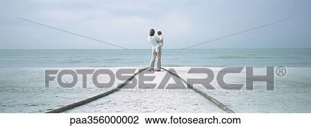 Mother and child standing at end of path on beach View Large Photo Image Stock Image - Mother and child standing at end of path on beach. Fotosearch