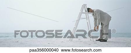 On beach, businessman sleeping standing up, resting head on ladder View Large Photo Image Stock Image - On beach, businessman sleeping standing up, resting head on ladder. Fotosearch