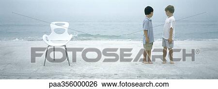 Two boys standing on beach, looking over shoulders at ocean View Large Photo Image Stock Photograph - Two boys standing on beach, looking over shoulders at ocean. Fotosearch