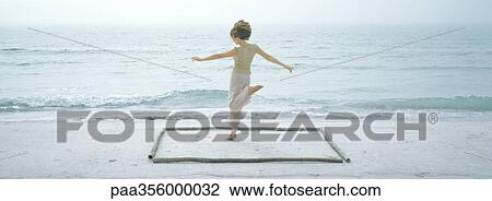 Stock Image - Woman jumping in square on beach. Fotosearch