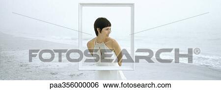 Woman standing on beach, behind frame View Large Photo Image Stock Photograph - Woman standing on beach, behind frame. Fotosearch