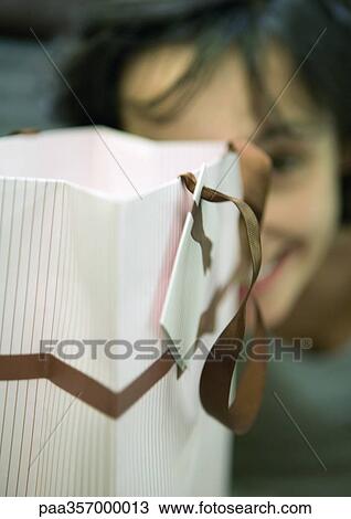 Shopping bag and woman's face in background View Large Photo Image Stock Image - Shopping bag and woman's face in background. Fotosearch