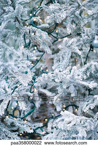 Stock Image - Christmas tree covered with lights, partial view. Fotosearch
