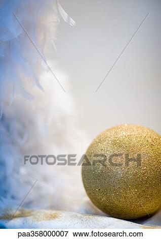 Stock Photo - Glittery ball and feathers, partial view. Fotosearch