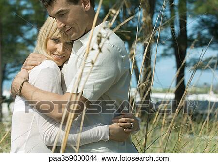 Couple embracing in tall grass View Large Photo Image Picture - Couple embracing in tall grass. Fotosearch