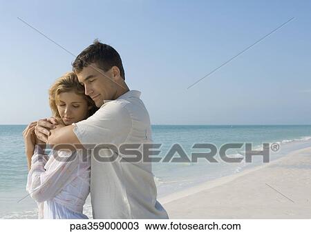 Couple embracing on beach View Large Photo Image Stock Image - Couple embracing on beach. Fotosearch
