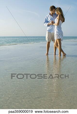 Stock Photo - Couple embracing on beach. Fotosearch