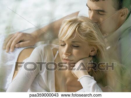 Stock Image - Couple lying down together, eyes shut. Fotosearch