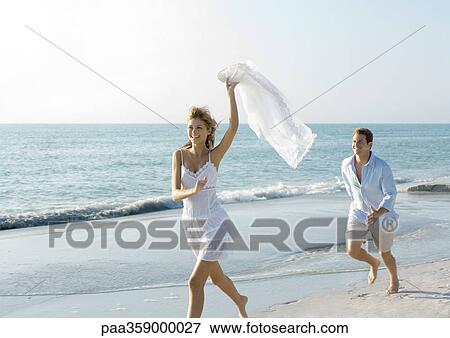 Couple on beach, man chasing woman View Large Photo Image Stock Photo - Couple on beach, man chasing woman. Fotosearch