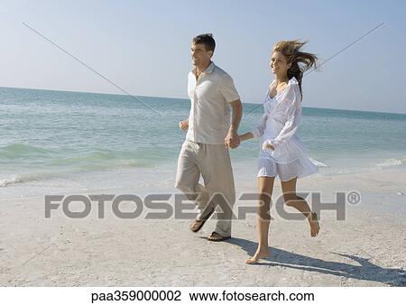 Couple running on beach View Large Photo Image Stock Image - Couple running on beach. Fotosearch