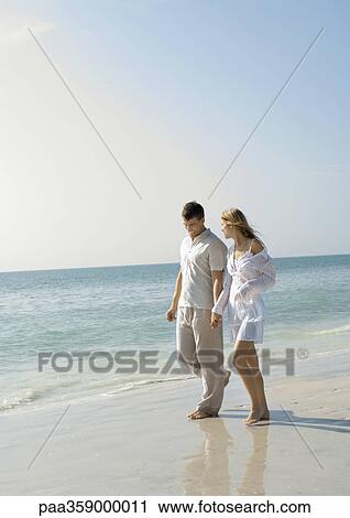 Couple walking on beach View Large Photo Image Stock Image - Couple walking on beach. Fotosearch