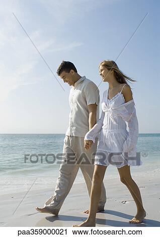 Couple walking on beach View Large Photo Image Stock Image - Couple walking on beach. Fotosearch