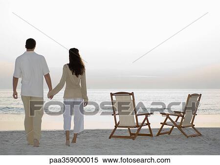 Newlyweds standing on beach, looking at view View Large Photo Image Stock Photography - Newlyweds standing on beach, looking at view. Fotosearch