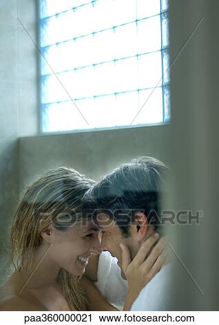 Stock Image - Couple smiling at each other, foreheads touching. Fotosearch