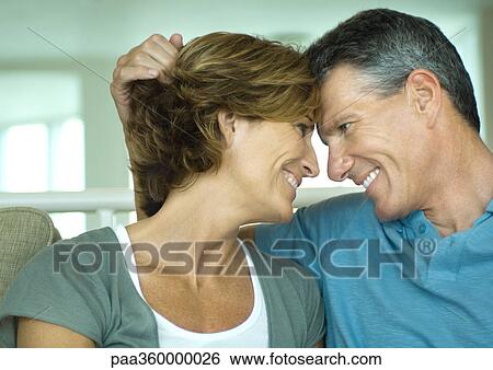 Stock Photograph - Mature couple smiling at each other, touching foreheads. Fotosearch