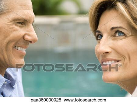 Mature couple smiling near water View Large Photo Image Stock Photo - Mature couple smiling near water. Fotosearch