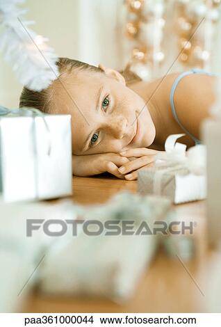 Girl lying on floor next to christmas presents View Large Photo Image Picture - Girl lying on floor next to christmas presents. Fotosearch