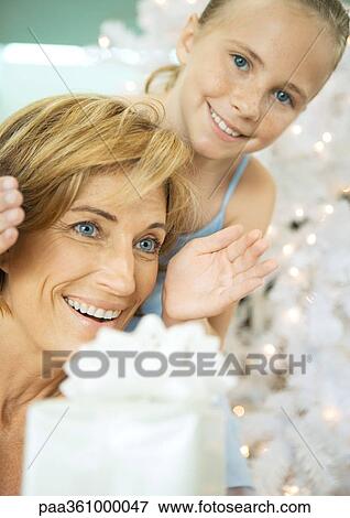 Girl surprising woman with christmas present View Large Photo Image Stock Photo - Girl surprising woman with christmas present. Fotosearch