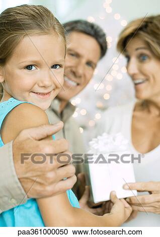 Little girl giving grandparents christmas present View Large Photo Image Stock Image - Little girl giving grandparents christmas present. Fotosearch