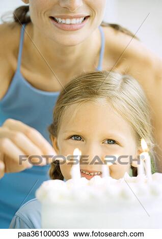 Mother lighting candles on birthday cake for girl View Large Photo Image Stock Image - Mother lighting candles on birthday cake for girl. Fotosearch