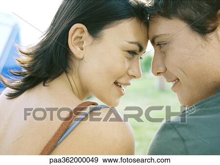 Stock Photo - Couple, touching foreheads and gazing at each other. Fotosearch
