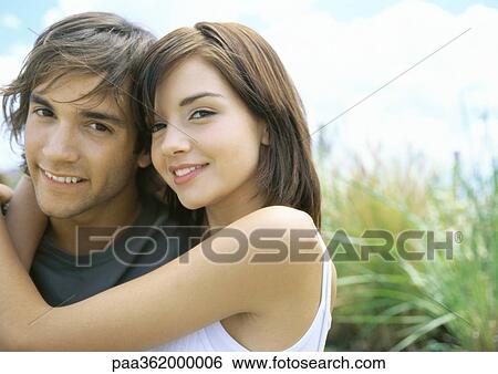 Young couple cuddling outdoors View Large Photo Image Stock Photograph - Young couple cuddling outdoors. Fotosearch