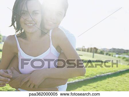 Young couple embracing outdoors View Large Photo Image Stock Photography - Young couple embracing outdoors. Fotosearch