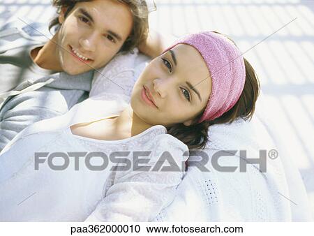 Stock Image - Young couple lounging outdoors. Fotosearch