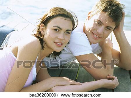 Young couple lying on dock View Large Photo Image Stock Photo - Young couple lying on dock. Fotosearch