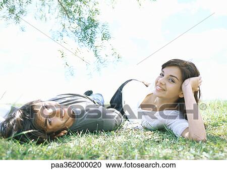 Young couple lying on grass View Large Photo Image Stock Image - Young couple lying on grass. Fotosearch