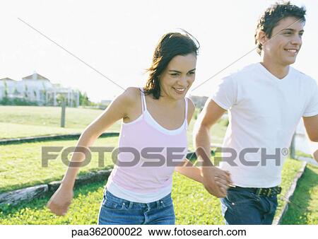 Young couple walking, holding hands View Large Photo Image Stock Image - Young couple walking, holding hands . Fotosearch