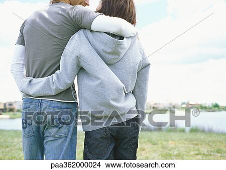Picture - Young couple walking outdoors, rear view . Fotosearch