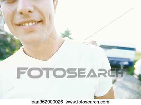 Stock Photograph - Young man, cropped view of head and shoulders. Fotosearch