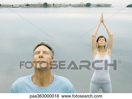 Couple doing relaxation exercises by edge of water View Large Photo Image Stock Photo - Couple doing relaxation exercises by edge of water. Fotosearch