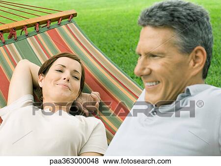 Couple lounging in hammock View Large Photo Image Stock Photo - Couple lounging in hammock. Fotosearch