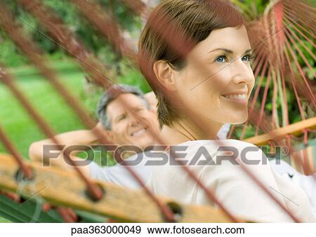 Couple lounging in hammock View Large Photo Image Stock Photo - Couple lounging in hammock. Fotosearch