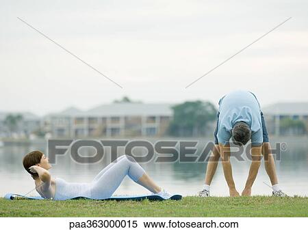 Stock Photography - Couple working out by edge of water. Fotosearch